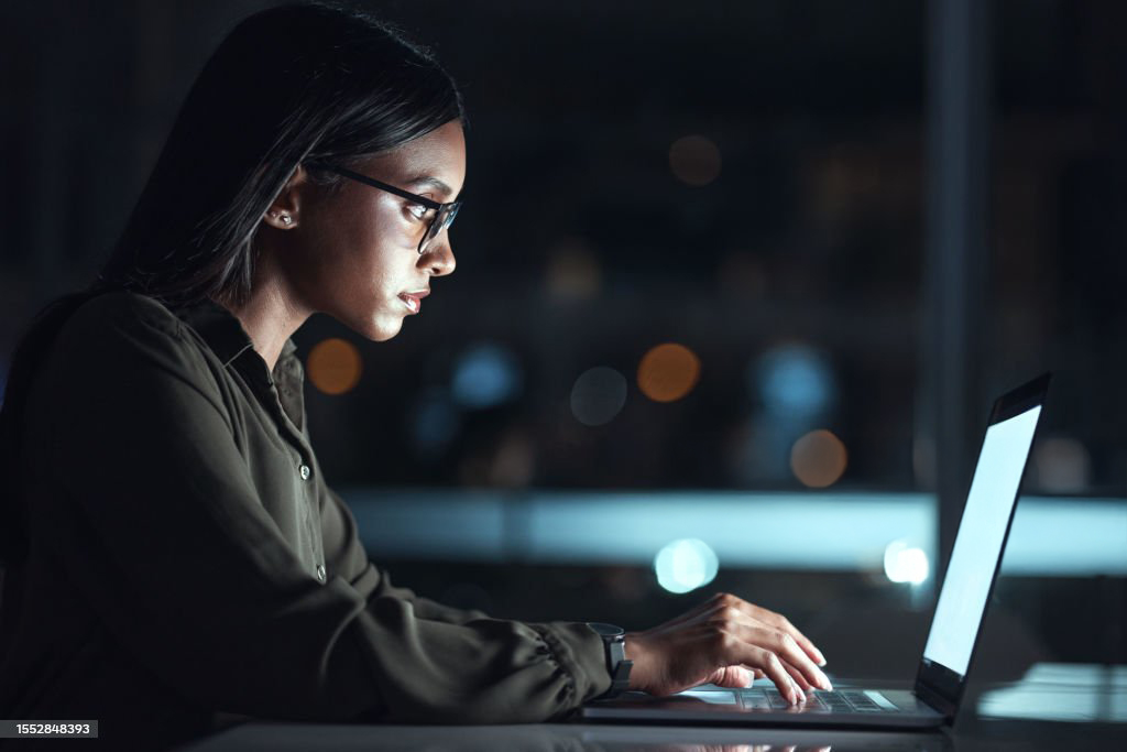 Female looking at computer at night